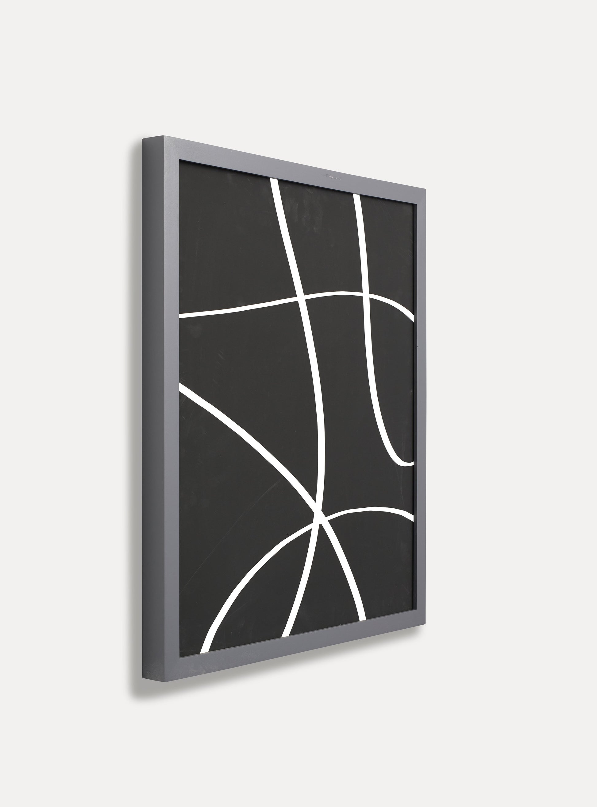 Side photo of a wooden picture frame on an off-white wall