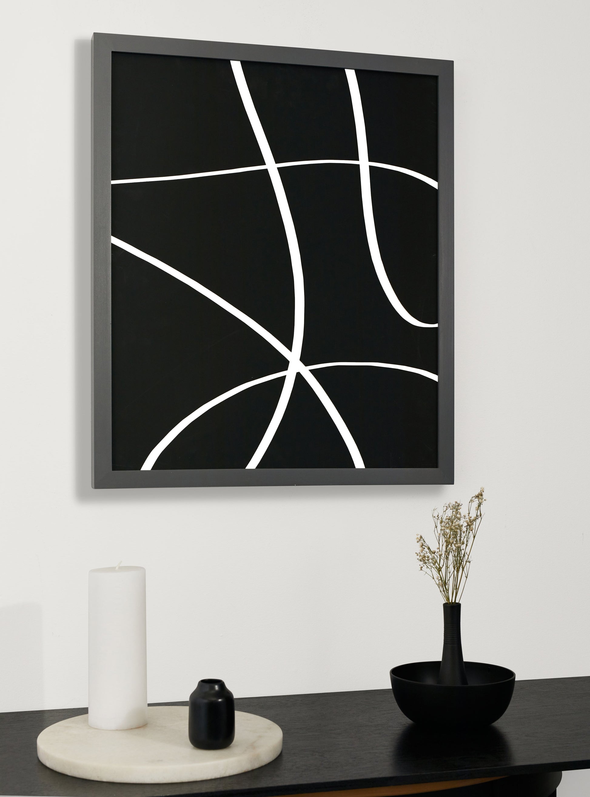 Photograph of a frame in a home with a table underneath showing various items