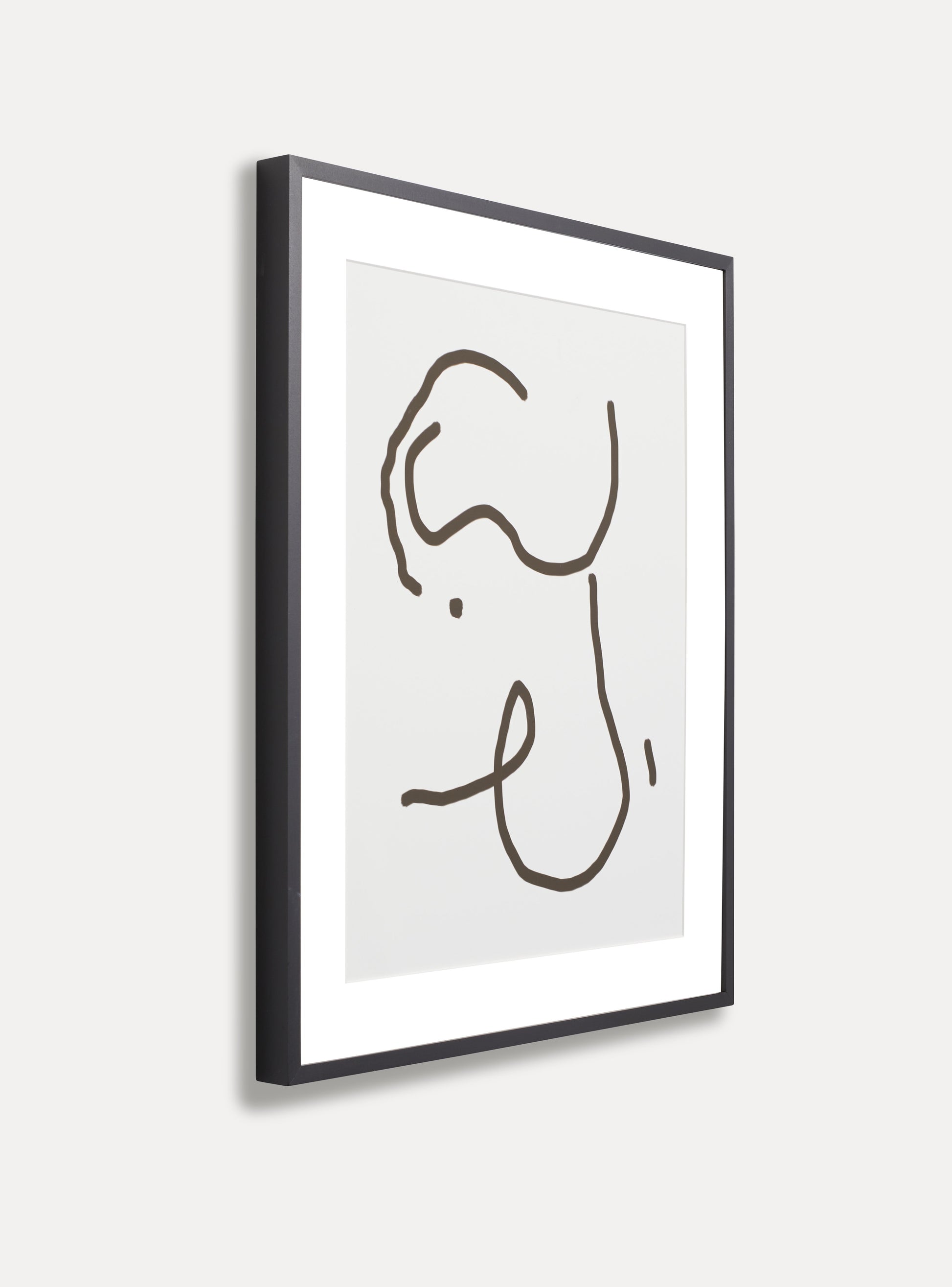 Side photo of a wooden picture frame on an off-white wall