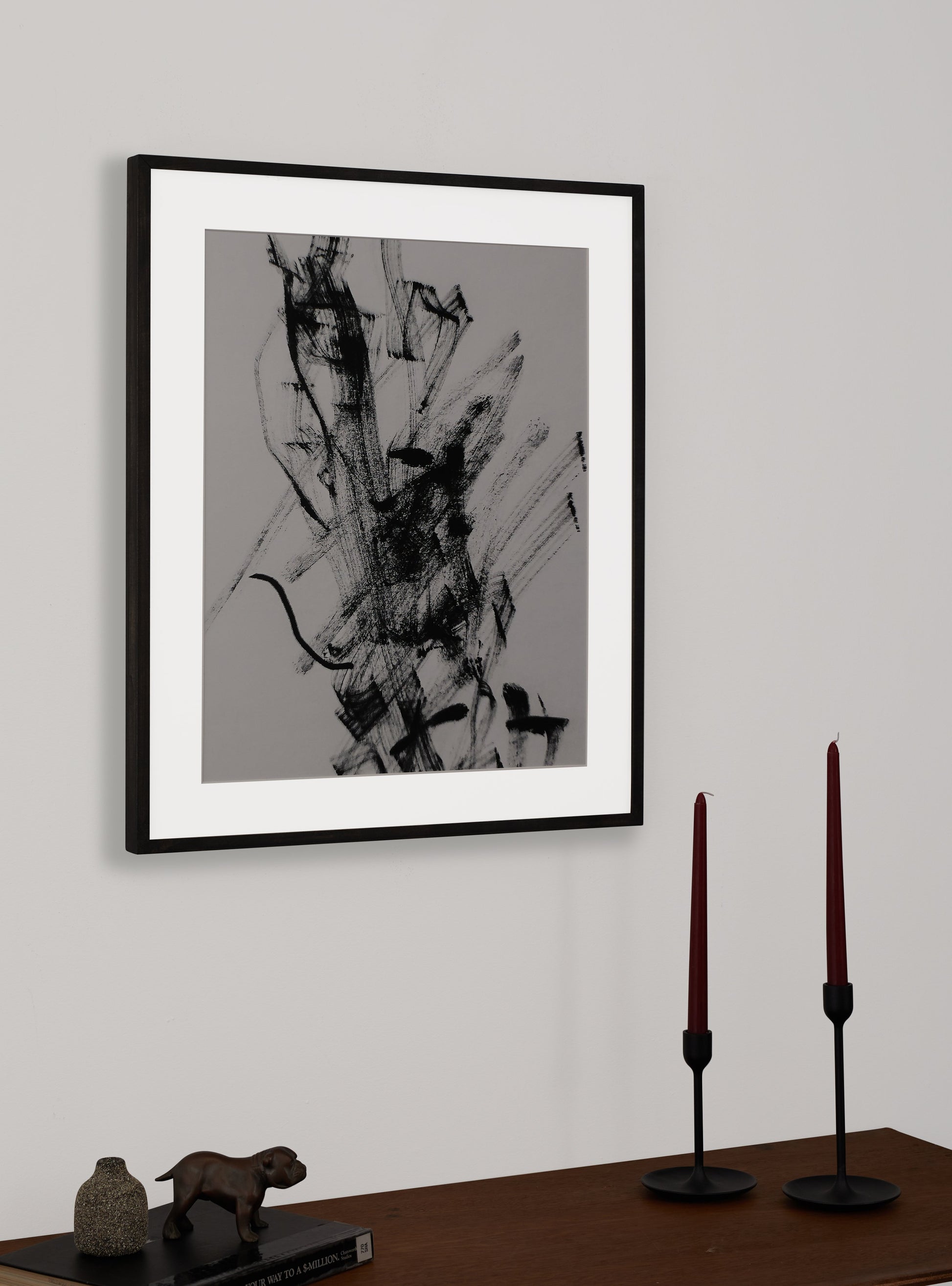 Photograph of a frame in a home with a table underneath showing various items