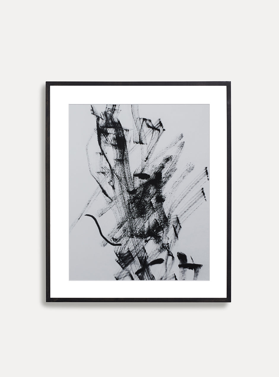 black and white abstract print in black frame on white wall