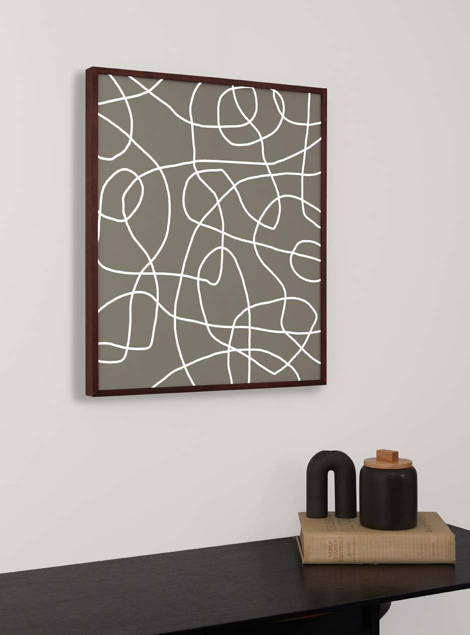 dark stained thin wooden frame holding abstract painting  hung above table with various objects