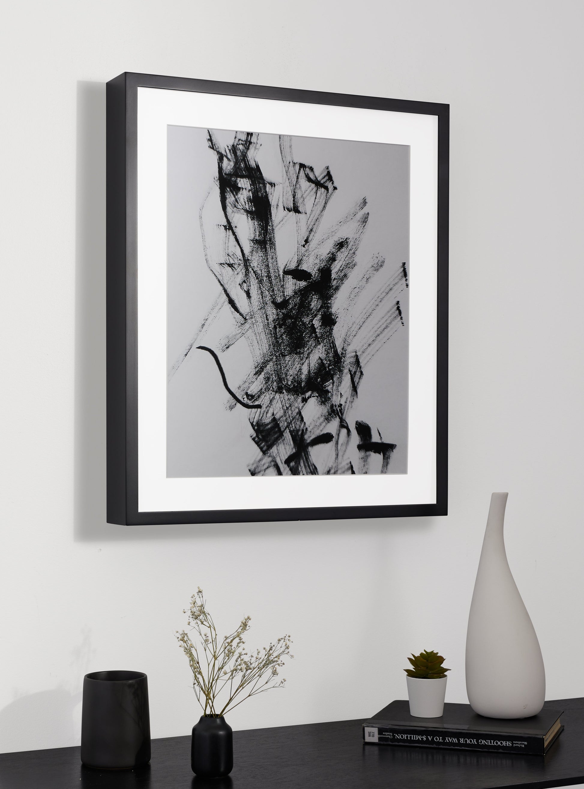 Photograph of a frame in a home with a table underneath showing various items