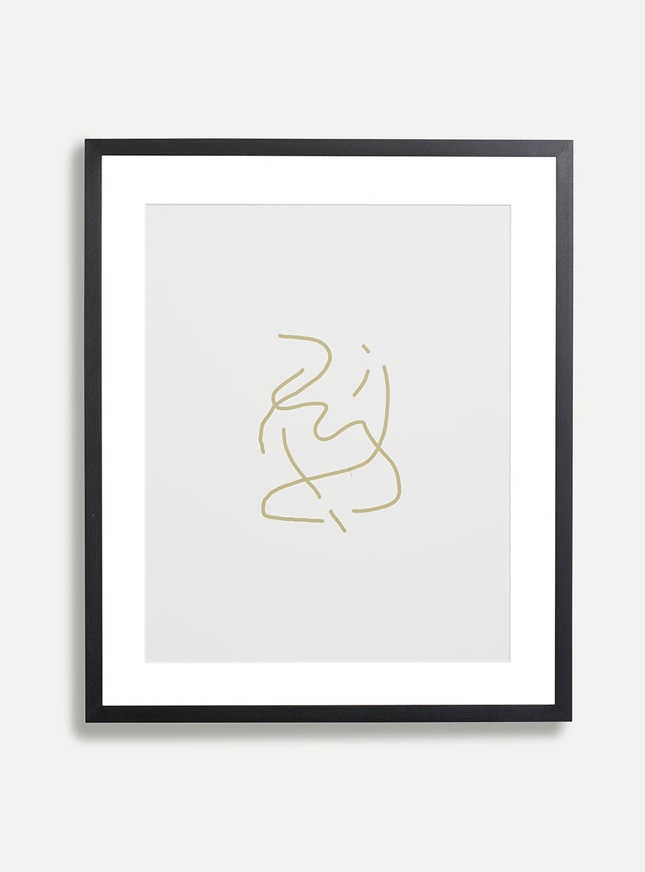 tan abstract art on white background in black frame on white wall