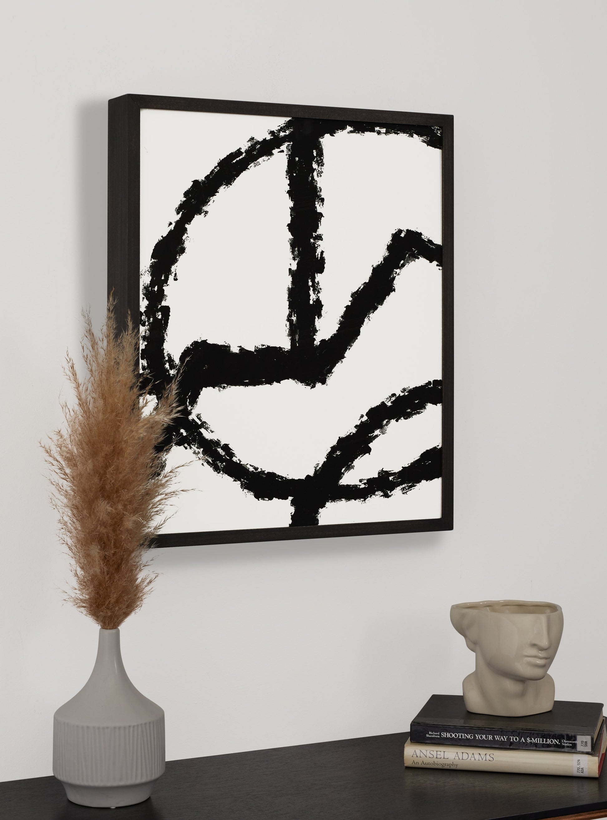 Photograph of a frame in a home with a table underneath showing various items