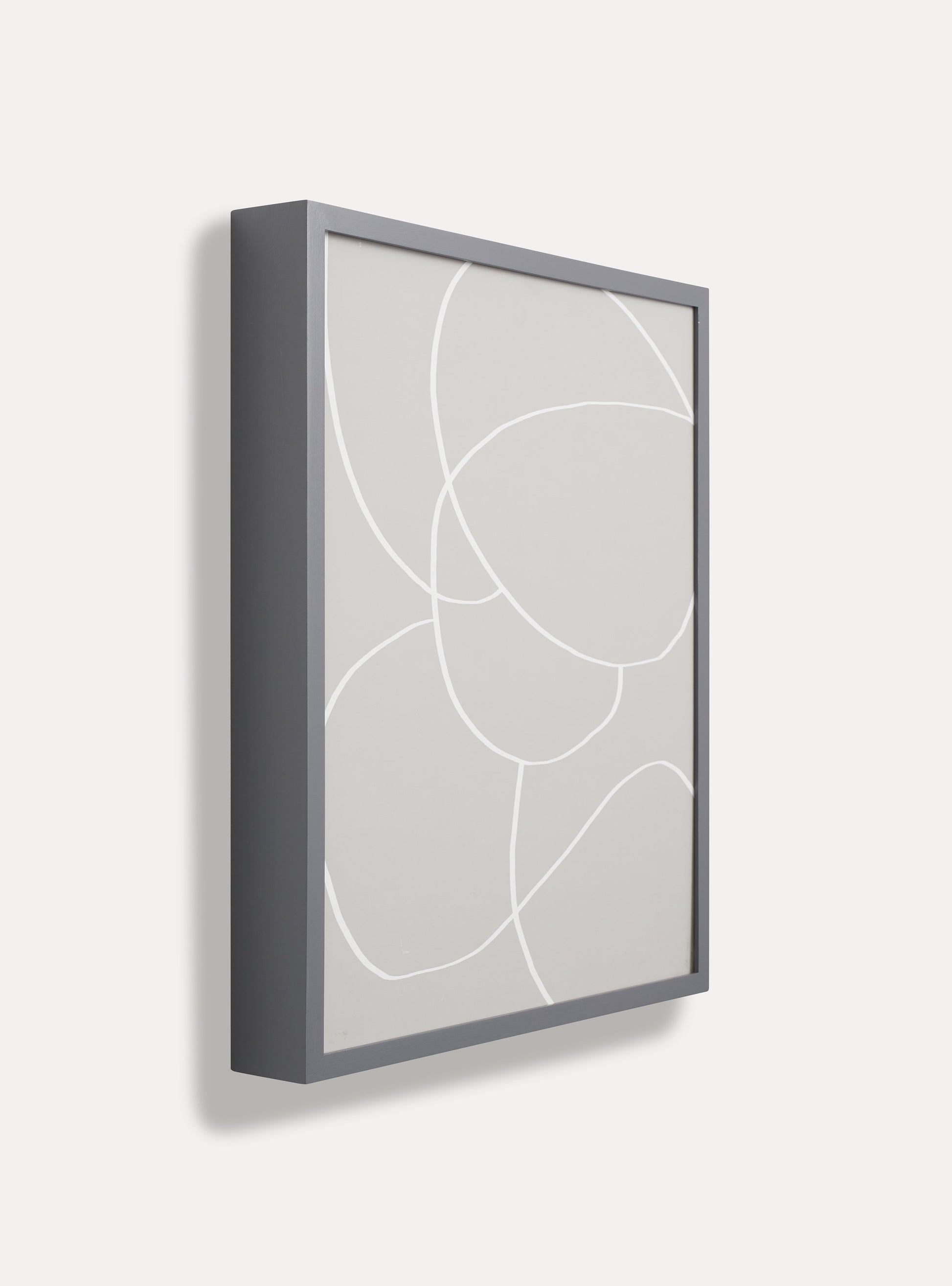 Side photo of a wooden picture frame on an off-white wall