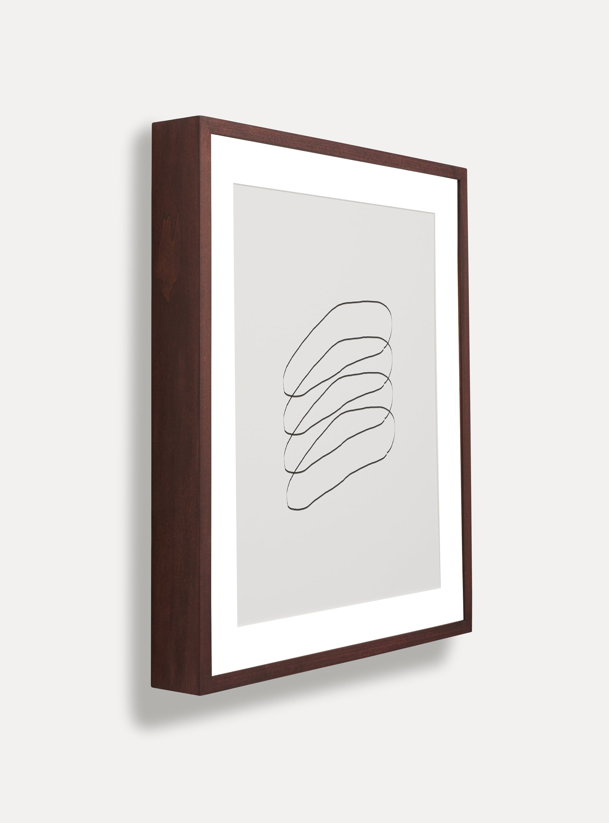 Side photo of a wooden picture frame on an off-white wall