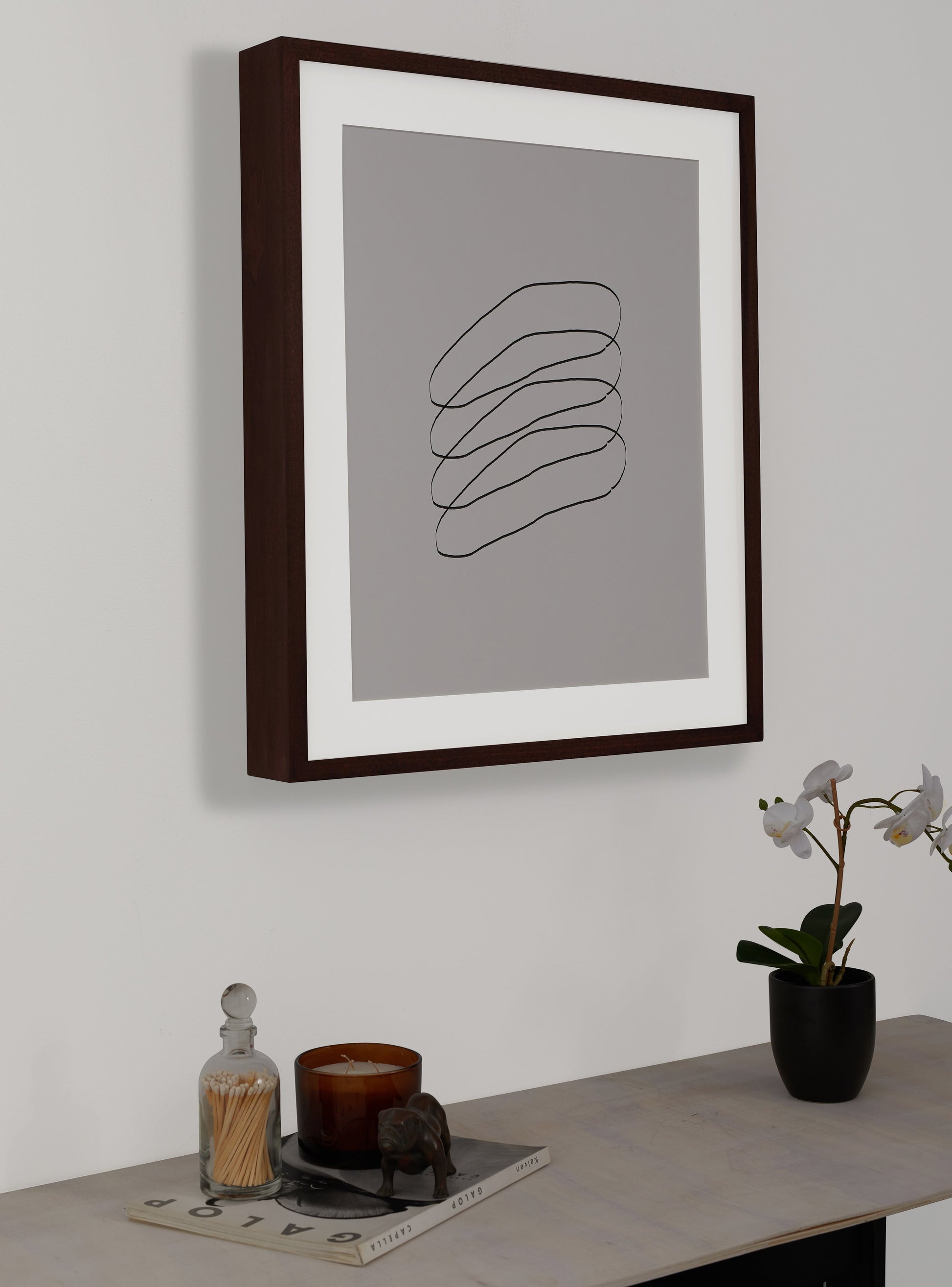 Photograph of a frame in a home with a table underneath showing various items