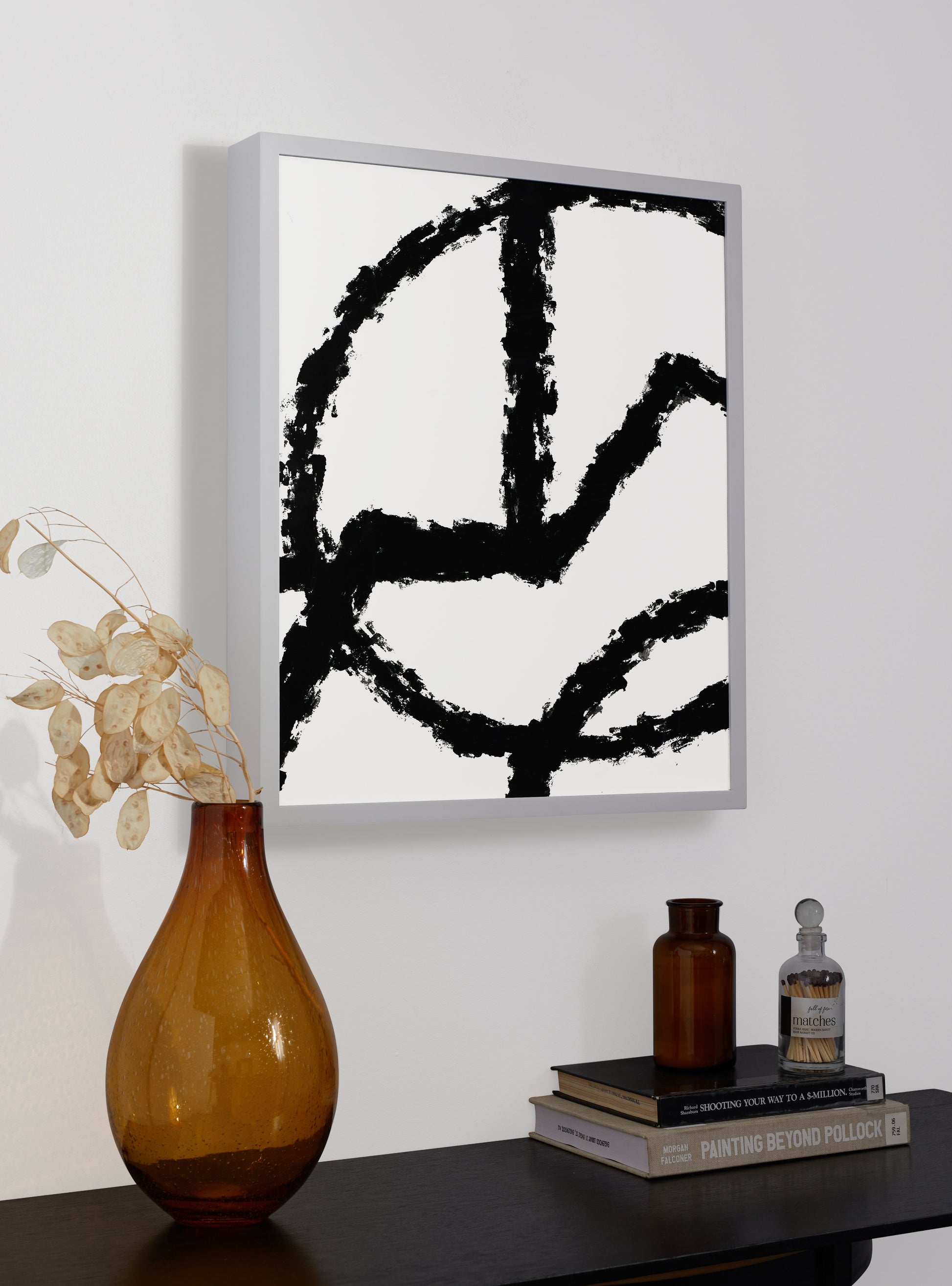 Photograph of a frame in a home with a table underneath showing various items