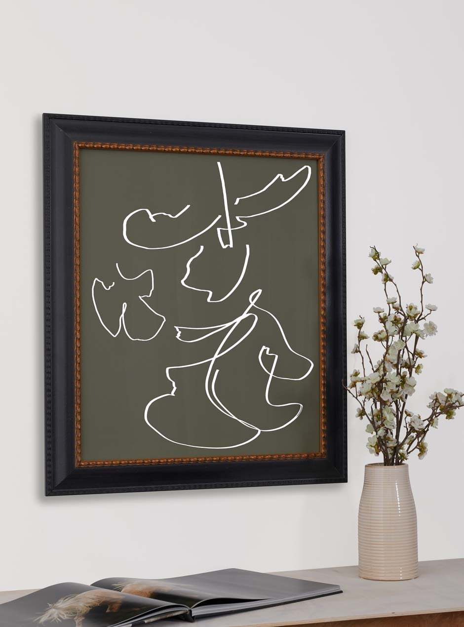 black frame with gold inner detailing holding abstract art hung above table with various objects