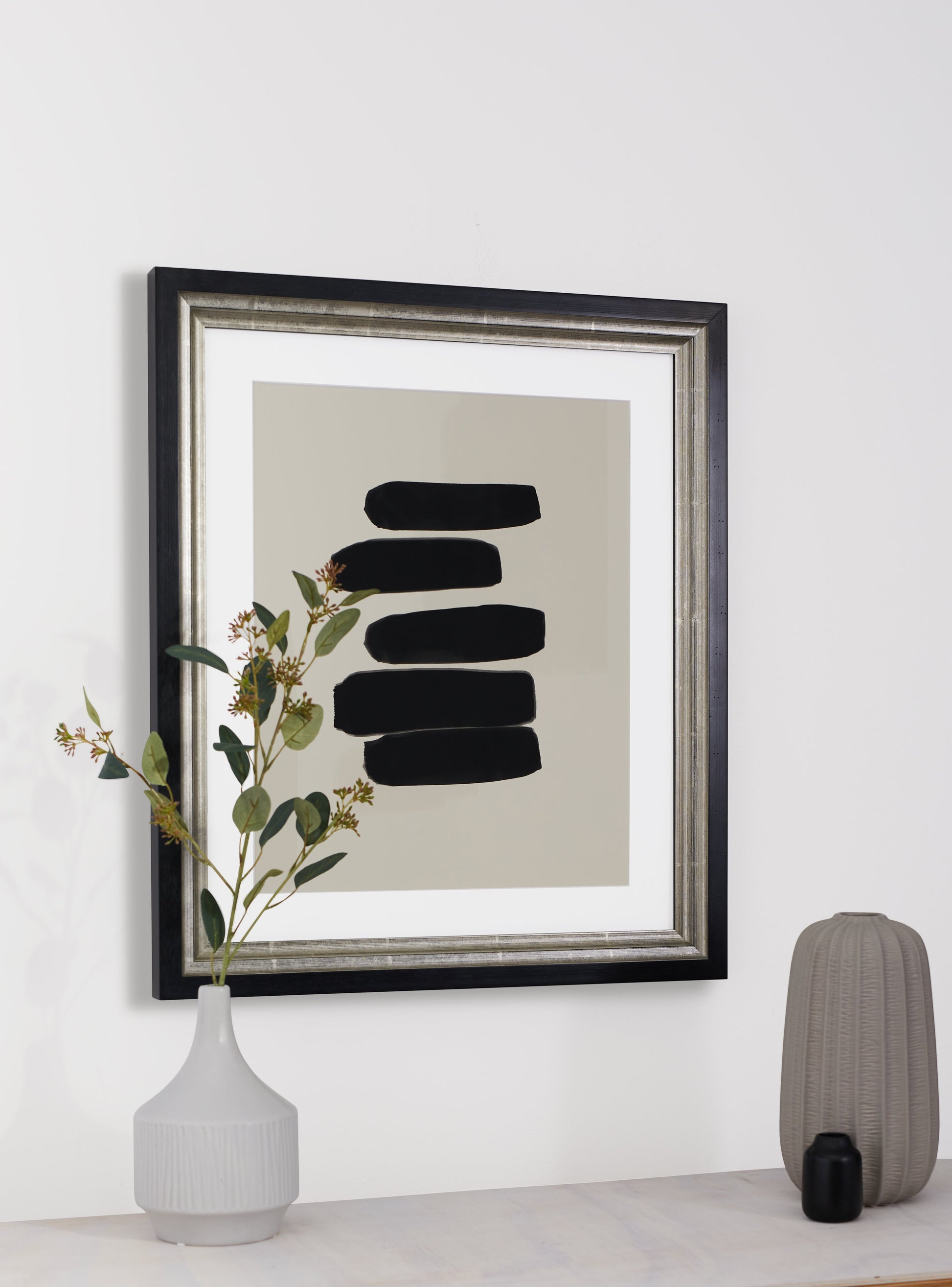 Photograph of a frame in a home with a table underneath showing various items