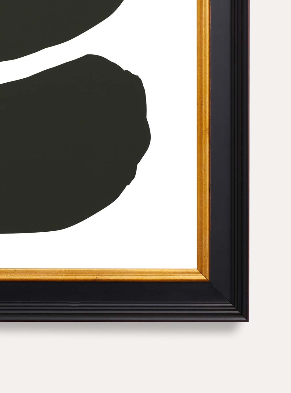 close up of the bottom corner of 3 abstract black shapes on a white background in a black and gold frame