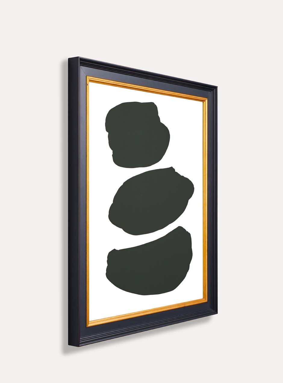 side view of 3 abstract black shapes on a white background in a black and gold frame