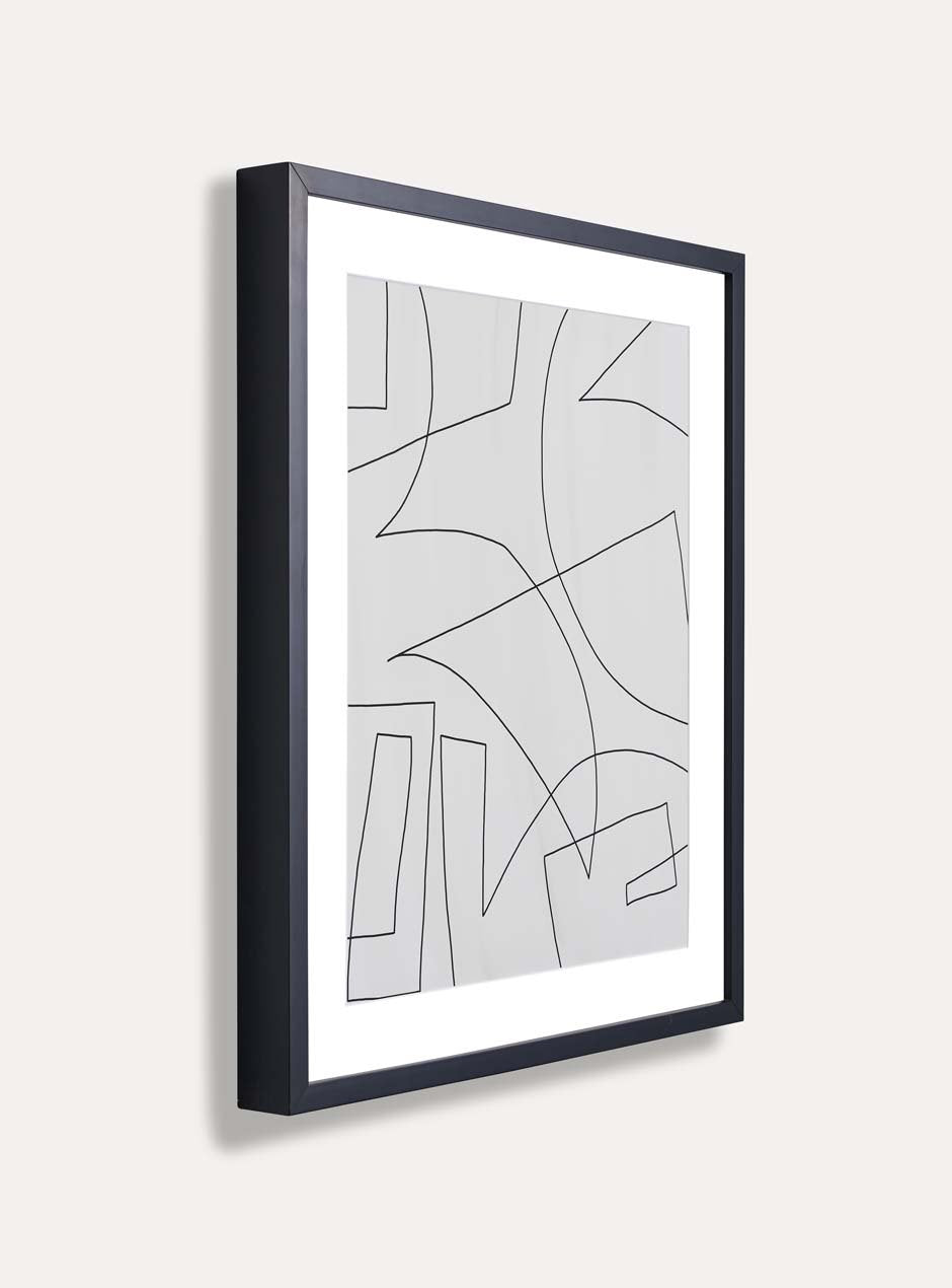 side profile showing depth of thin modern black wood frame with white matboard and linear modern abstract artwork on a white wall