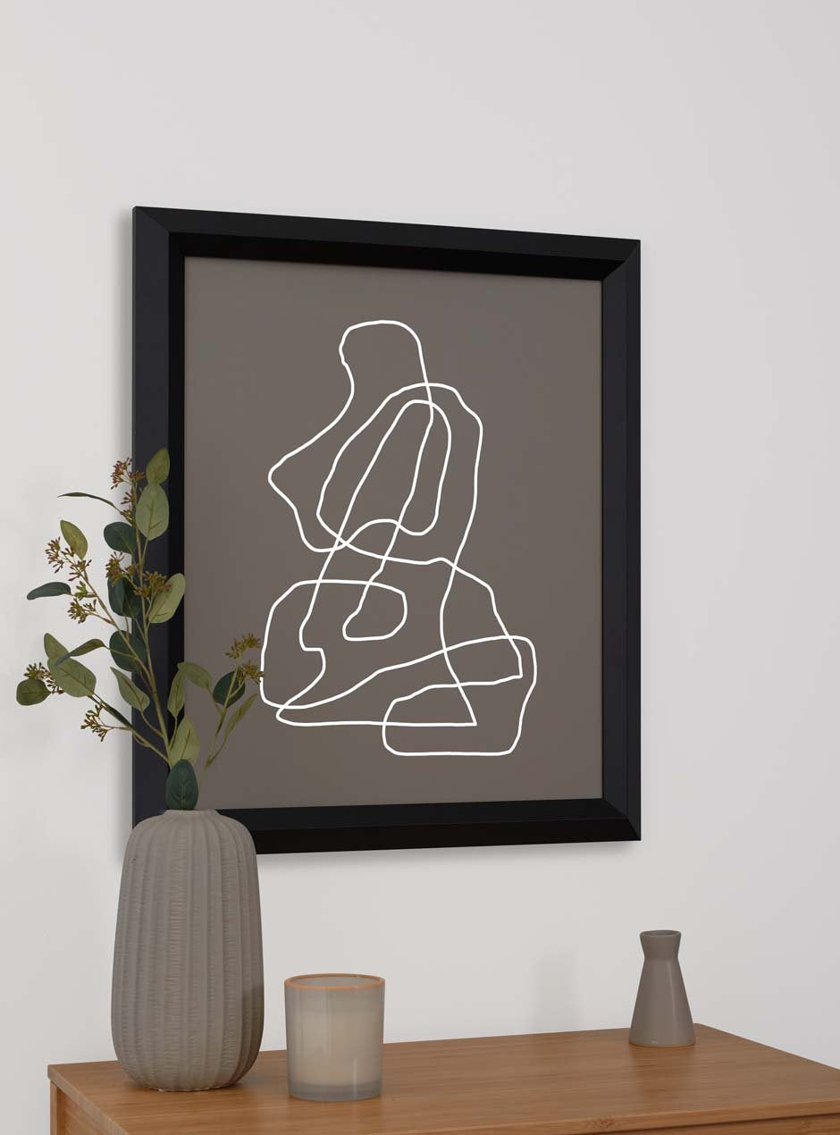 black frame holding abstract art hung above table with various objects