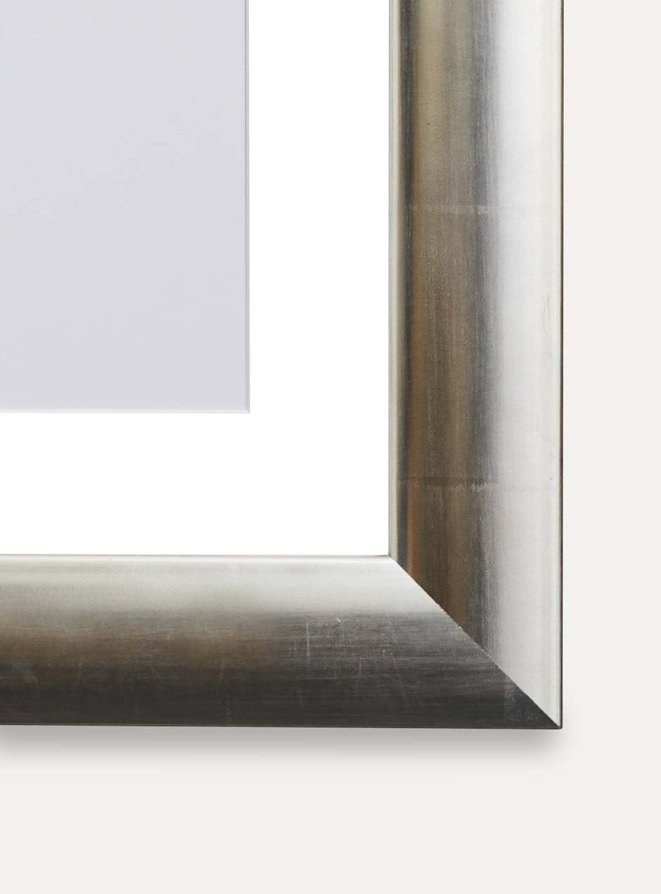 close up of corner of silver frame holding abstract black and white painting 